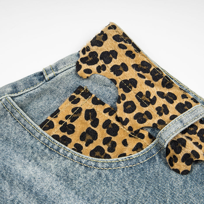 Close-up of leopard print waistband detail on light wash denim shorts