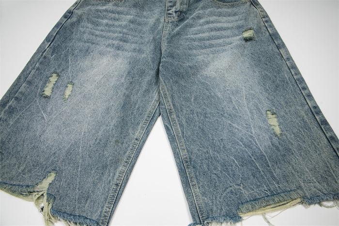 Front close-up of distressed denim shorts with frayed hems and ripped details