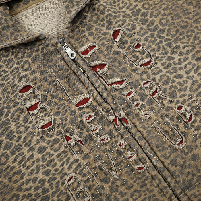 Close-up of distressed embroidered letters on leopard print hoodie front