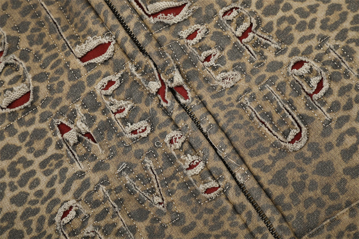 Close-up of distressed letter embroidery and front zipper on leopard print hoodie