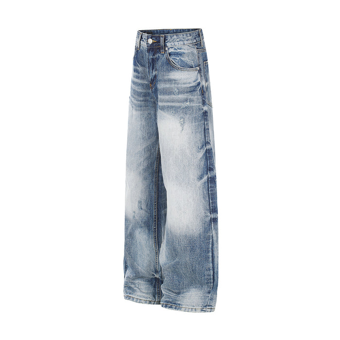 Angled side view of light blue washed jeans showing the wide leg, front pocket and distressed fading