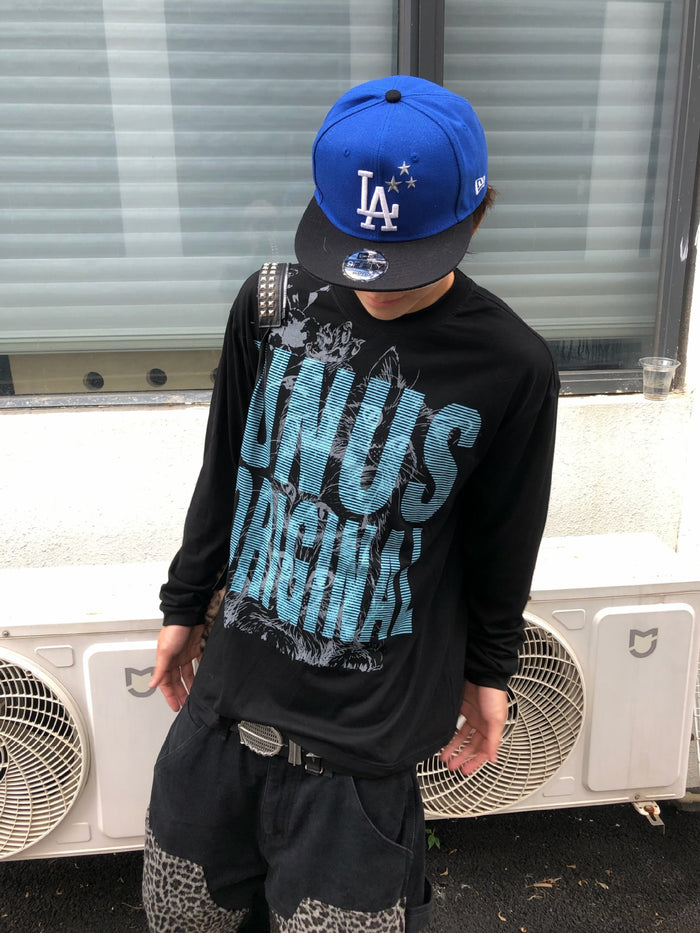 Model wearing a black long sleeve shirt with a large blue UNUS cat graphic on the front