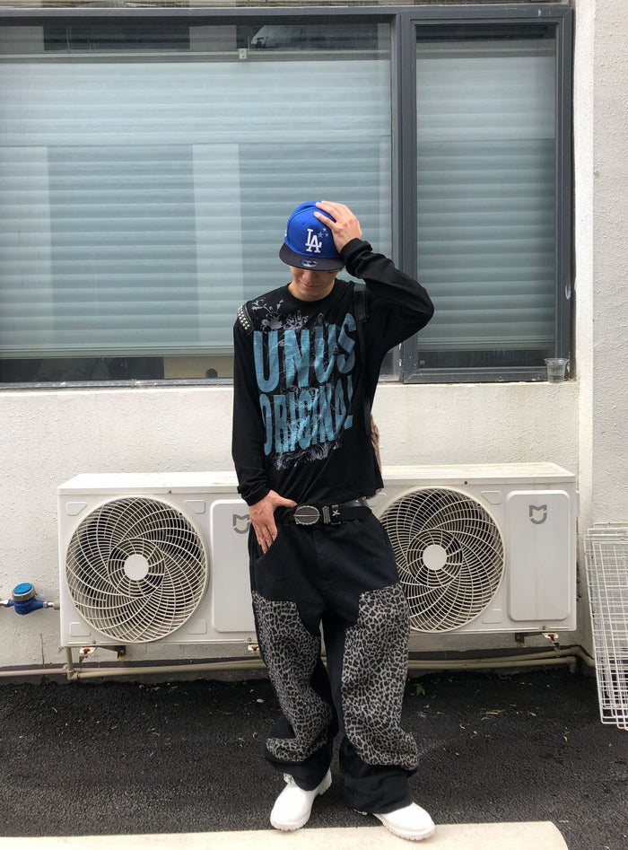 Full-body model view of a black long sleeve UNUS cat graphic shirt with blue front print