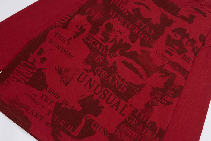 Close-up of the red shirt front showing dark collage artwork, silhouettes, and layered printed text