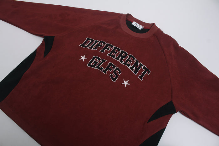 Flat lay of burgundy suede-texture tee with DIFFERENT GLFS arch graphic and contrasting black side panels