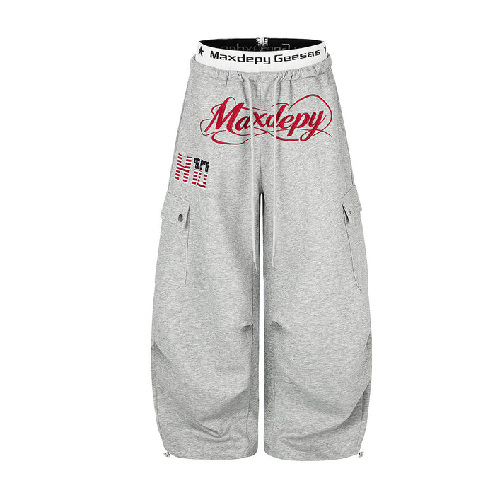 Loose fit wide-leg cargo sweatpants with embroidered Maxdepy logo in heather gray, featuring snap cargo pockets and branded e
