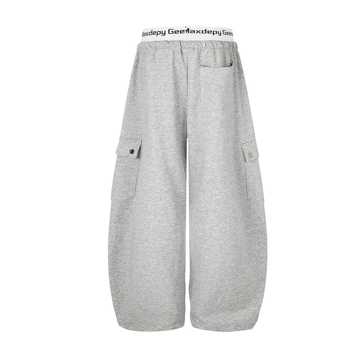 Back view of gray wide-leg cargo sweatpants with flap cargo pockets and elastic waistband