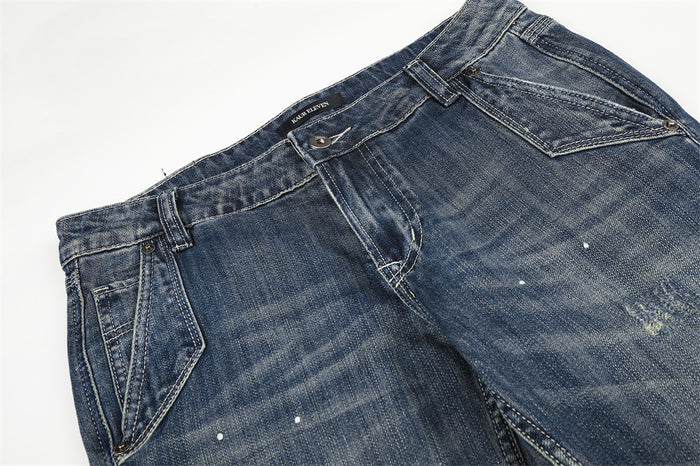 Close-up of the front waist on blue low rise jeans with belt loops and pocket detail