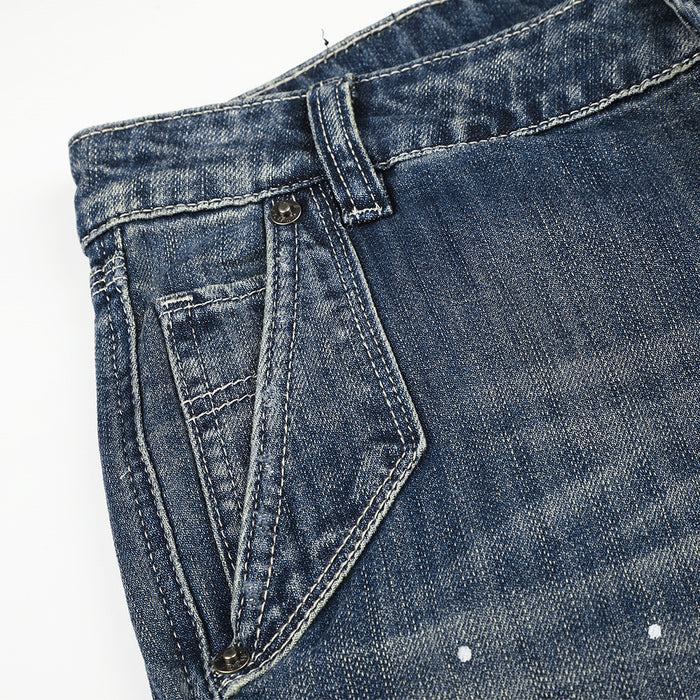 Close-up of front pocket and waistband on blue distressed denim jeans