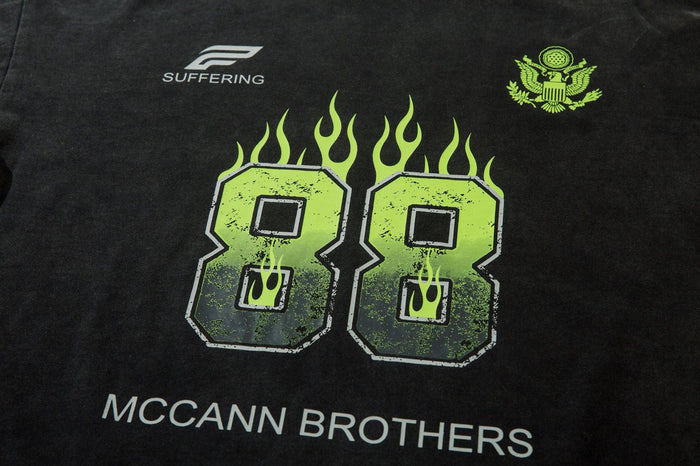 Close-up of black front graphic with neon green flaming 88 and McCann Brothers text