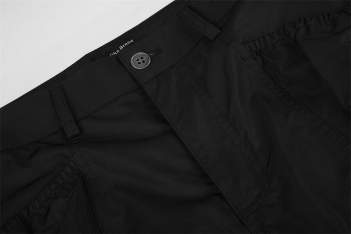 Close-up of black waistband and front button closure on cargo pants