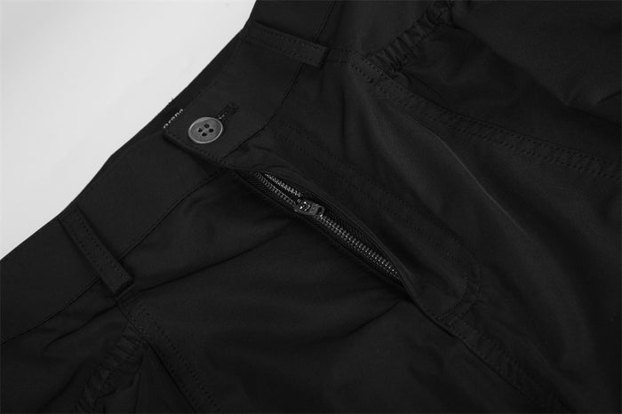 Close-up of black cargo pants front pocket zipper and waistband
