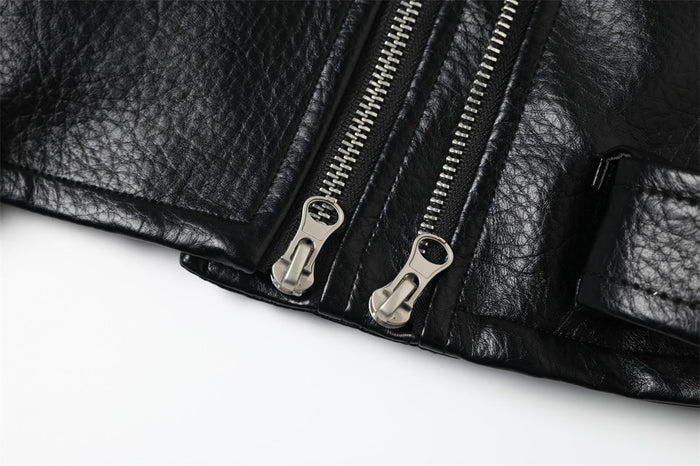 Close-up of lower front hem with two silver zipper pulls on black leather jacket