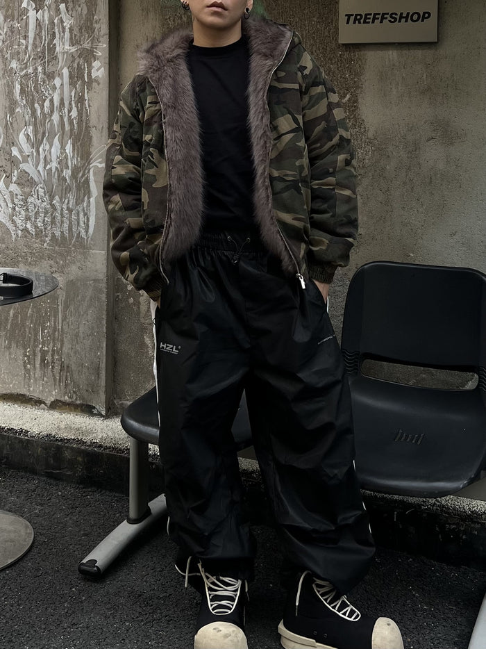 Camouflage faux fur-lined hooded bomber jacket worn open, showing the brown fur trim and ribbed cuffs