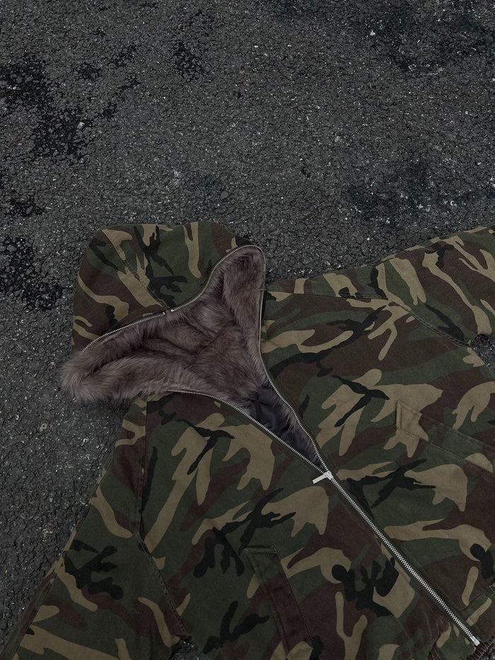 Top detail of a camouflage bomber jacket showing the fur-lined hood, front zipper, and shoulder area