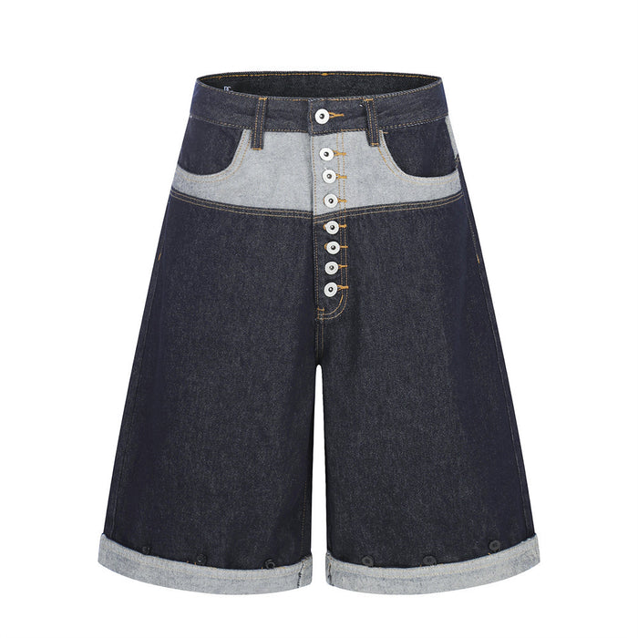 Men's dark indigo contrast patchwork wide-leg denim shorts with exposed button fly and rolled cuff hem, front view