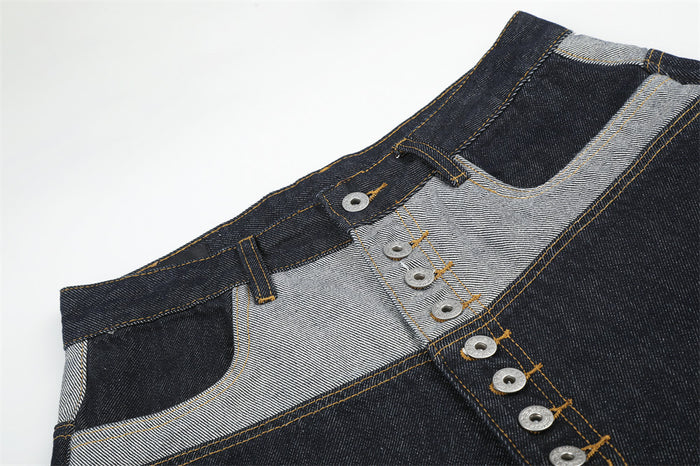 Close-up of denim shorts front waistband with contrast patchwork and button-fly detail