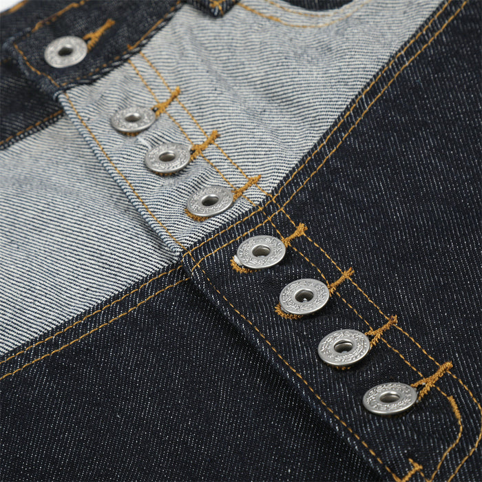 Close-up of silver button-fly closure on contrast patchwork denim shorts