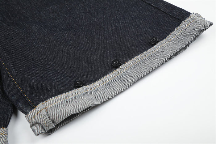 Close-up of rolled denim hem with visible stitching and button details