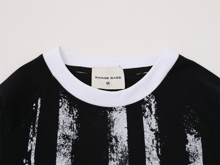 Close-up of the tee's white ribbed crew neckline, black upper panel, distressed stripe print and sewn label
