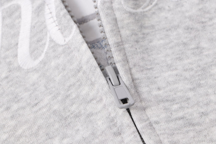 Close-up of light gray zipper and front seam on zip hoodie