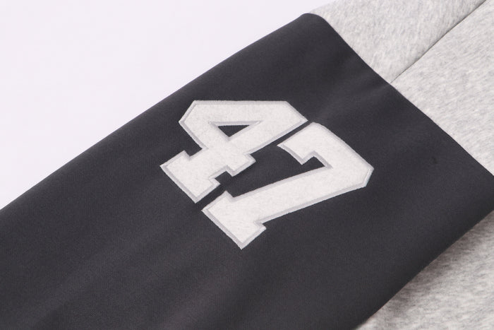 Close-up of black sleeve with large white 47 patch on varsity hoodie