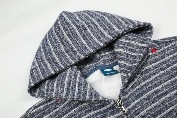 Close-up of the navy striped hoodie showing the hood, collar, zipper, and red shoulder accent