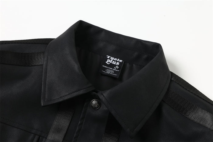 Black jacket collar close-up with buttoned front and tape trim on shoulders