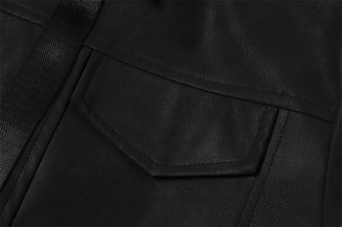 Close-up of black jacket front pocket flap and tape trim detail