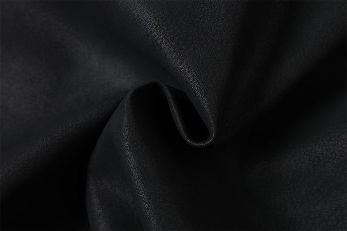 Close-up of black PU leather fabric with soft matte sheen and fold detail