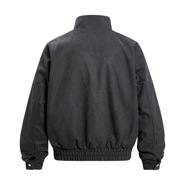 Black bomber jacket shown from the back with a raised collar, sculptural sleeve seams, and elasticated hem