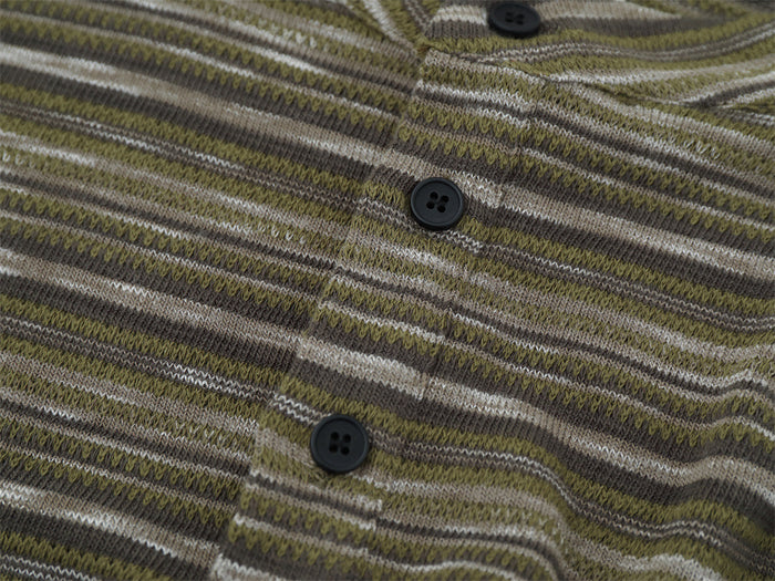 Close-up of black buttons on the olive striped knit henley shirt placket