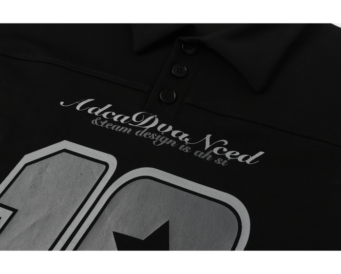 Close-up of front graphic and script text on black polo shirt