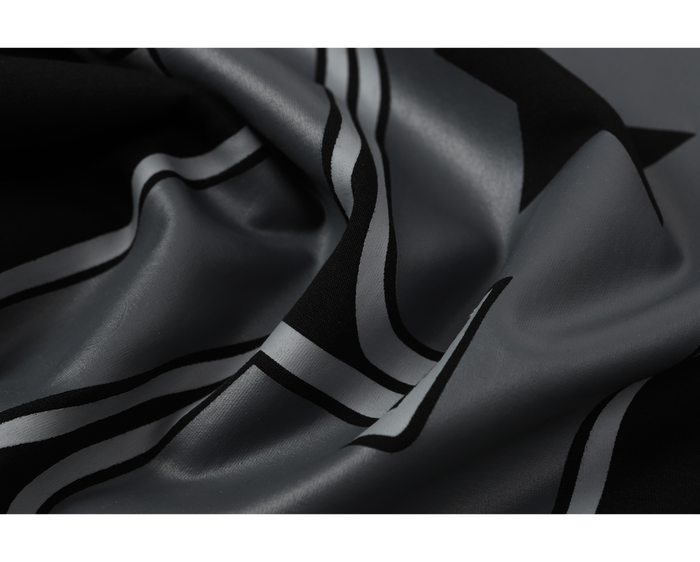 Close-up of gray and black printed fabric with striped camo-style design