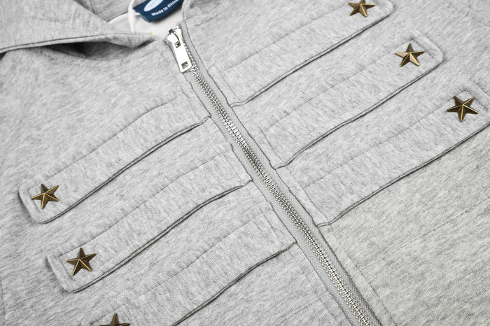 Close-up of the heather gray hoodie jacket zipper and chest tabs with metallic star studs