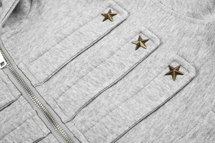 Detailed view of three metallic star studs attached to the gray chest tabs beside the zipper