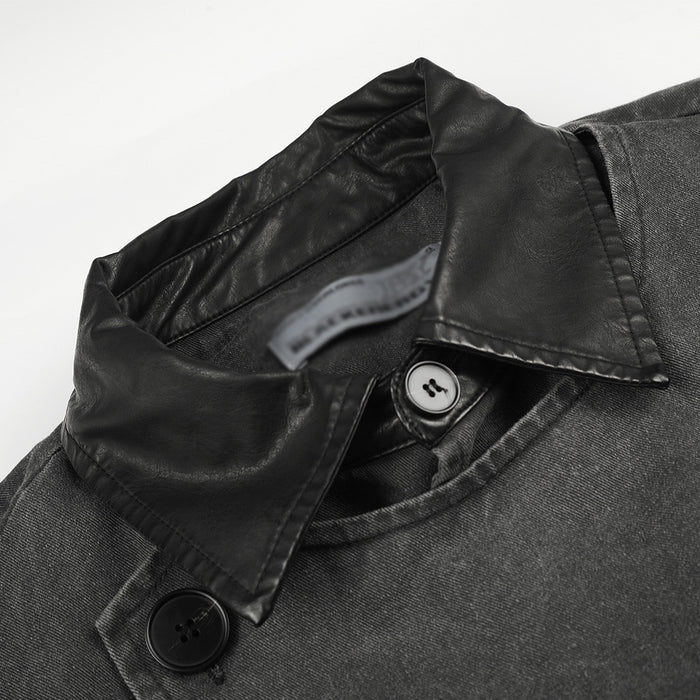 Close-up of black faux leather collar and irregular button placket on a charcoal jacket