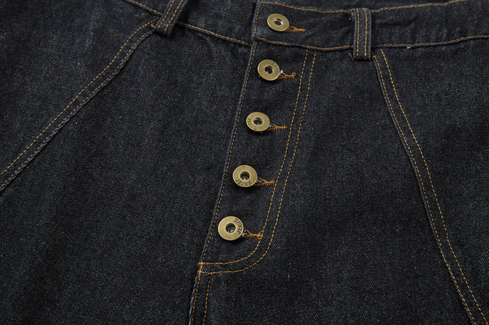 Close-up of five-button fly on dark denim pants with contrast stitching