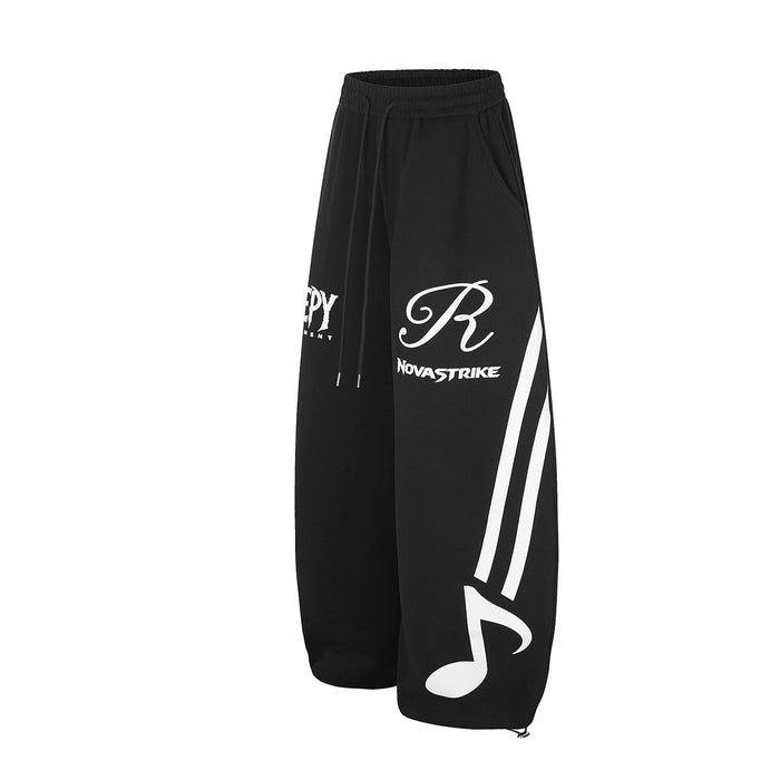 Black wide-leg sweatpants in an angled front view with white musical note and stripe graphics