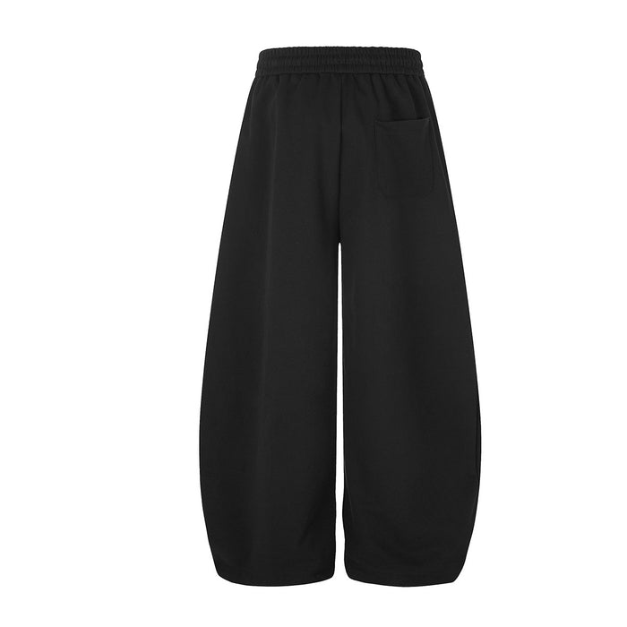 Plain black wide-leg sweatpants shown from the back with an elastic waistband and relaxed fit