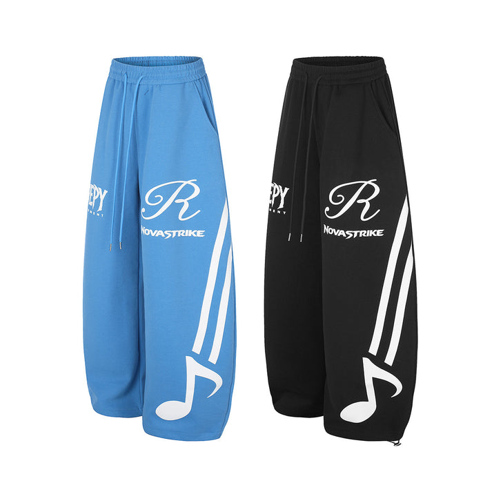 Blue and black wide-leg sweatpants in angled views with white music graphics and elastic waistbands