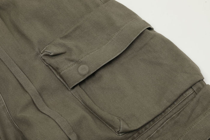Close-up of olive cargo pants side pocket and hem stitching