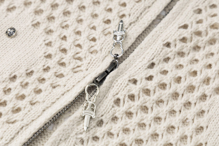 Close-up of the cream hoodie’s metal zipper, decorative pull, and openwork knit texture