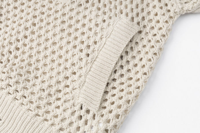 Cream openwork knit hoodie pocket opening with ribbed trim and textured stitching