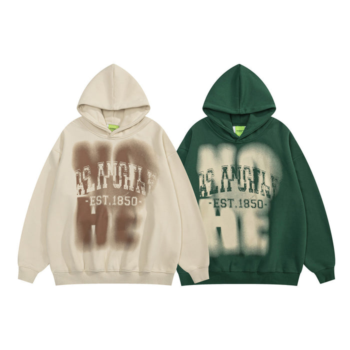 Two oversized hoodies, cream and dark green, featuring blurred Los Angeles EST.1850 front prints