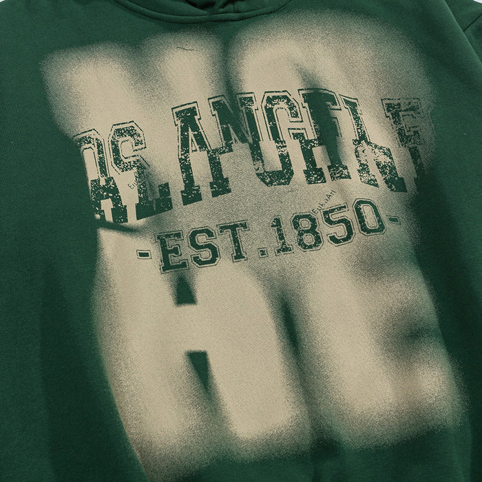 Detailed view of the blurred Los Angeles EST.1850 graphic on the dark green hoodie front
