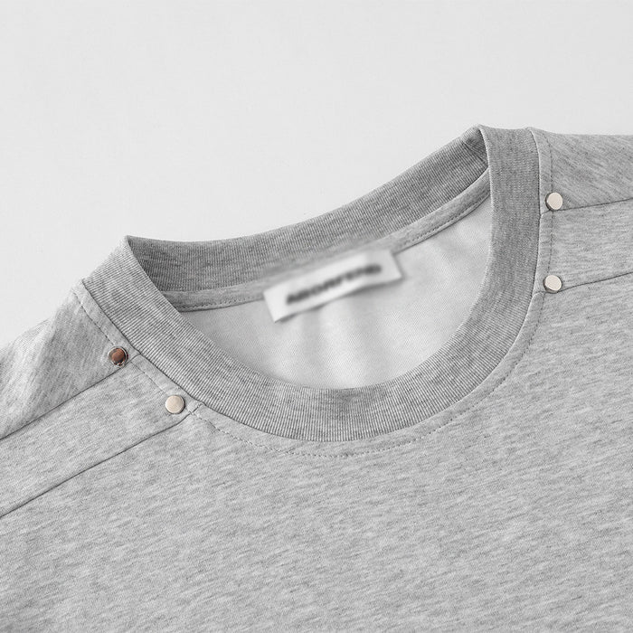 Close-up of light gray T-shirt neckline and studded shoulder seam