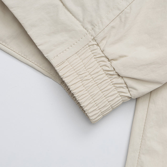 Close-up of the cream jacket sleeve with a gathered elastic cuff and reinforced seam stitching