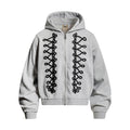 Light gray zip-up hoodie with black looped rope-lace panels, hood, ribbed cuffs, and hem