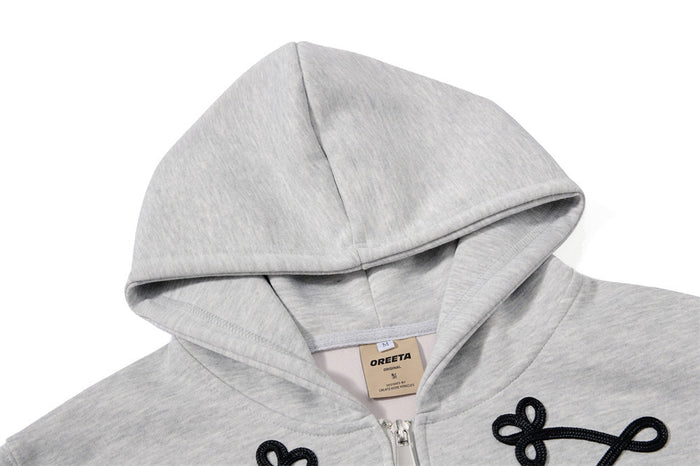 Close-up of the light gray hoodie hood, inner neckline, zipper, and black rope-lace trim